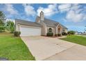Single-story home boasts stone accents, a neutral exterior, attached garage, and a well-manicured lawn at 5669 Blackberry Row, Ellenwood, GA 30294