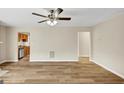 Bright living room boasts wood-look flooring, a ceiling fan, and an open view to the kitchen at 5669 Blackberry Row, Ellenwood, GA 30294