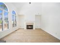 Cozy living room with a fireplace, large arched window and high vaulted ceilings at 225 S South Shore Ter, Fayetteville, GA 30214