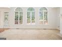 Bright living room featuring large windows, neutral carpet, and a door to the outside deck at 225 S South Shore Ter, Fayetteville, GA 30214