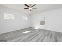This is a bright bedroom featuring wood-look floors, a ceiling fan and three windows letting in lots of natural light at 458 Prescott Way, Villa Rica, GA 30180