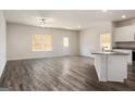 Spacious living room area with abundant natural light and modern flooring connects to the kitchen at 601 Mackenzie Cove, Villa Rica, GA 30180