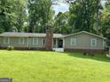 Ranch-style home with a tidy front lawn and a combination brick and siding exterior under a canopy of trees at 142 Carrollwood Dr, Fayetteville, GA 30215