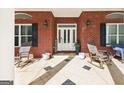 Inviting front porch with rocking chairs and tiled flooring, creating a cozy outdoor seating area at 270 Morrow Rd, Newborn, GA 30056