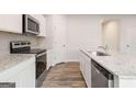 Modern kitchen featuring stainless steel appliances, granite countertops, and white cabinets at 7226 Lacey Drive # 125, Douglasville, GA 30134