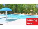 Community pool with clear blue water, lounge chairs and sun umbrellas; Coming Soon sign at 1483 Autumn Wind Dr # 24, Dacula, GA 30019