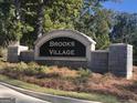 Stone entrance sign for Brooks Village with manicured landscaping and vibrant foliage at 1483 Autumn Wind Dr # 24, Dacula, GA 30019