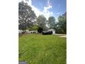 Large green backyard featuring mature shade trees and providing space for relaxation and recreation at 4111 Scott Dr, Forest Park, GA 30297