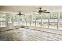 Bright sunroom with many windows offering backyard views and light wood-look flooring at 101 Bluegill Trce, Peachtree City, GA 30269