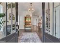 Grand foyer with hardwood floors, stylish chandelier, and vintage hutch at 405 Bandon Way, Peachtree City, GA 30269
