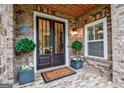 Inviting entryway with elegant double doors, manicured plants, and brick accents at 405 Bandon Way, Peachtree City, GA 30269