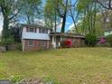 Charming split-level home with brick facade and red shutters is surrounded by a well-manicured lawn at 5637 Sturbridge Way, South Fulton, GA 30349