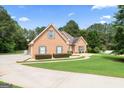 A lovely home with brick, a well-kept lawn, mature trees, and a paved driveway at 1010 Elaine Ct, Mcdonough, GA 30252
