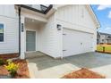 Charming home features a clean white exterior, two-car garage and well-manicured front yard at 8502 Polston Place # 144, Douglasville, GA 30134