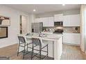 Modern kitchen with stainless steel appliances, white cabinets and a center island with bar stool seating at 8502 Polston Place # 144, Douglasville, GA 30134