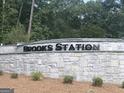Brooks Station neighborhood sign in stone with manicured bushes, showing a welcoming community entrance at 1949 Van Allen Ct # 4, Dacula, GA 30019
