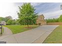 Spacious driveway leading to a well-maintained home with mature trees at 321 Champions Dr, Fairburn, GA 30213