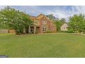 Beautiful home exterior featuring a well-maintained lawn and lush greenery at 321 Champions Dr, Fairburn, GA 30213