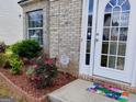 View of front entrance with colorful welcome mat, landscaping, and brick exterior at 1762 Wood Stork Drive, Hampton, GA 30228