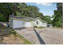 A single-story home showcasing an attached two-car garage with a long driveway leading to the front entrance at 4954 Browns Mill Rd, Lithonia, GA 30038