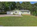 Charming single-story home featuring an attached two-car garage and a well-maintained front yard at 4954 Browns Mill Rd, Lithonia, GA 30038