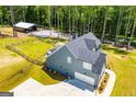 Back aerial of the home showing a fenced in yard, detached garage, and spacious driveway at 457 Paynes Lake Rd, Carrollton, GA 30116