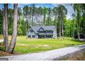 Wide view of the blue two-story home featuring a large lawn and tree-lined property at 457 Paynes Lake Rd, Carrollton, GA 30116
