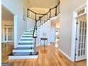 Inviting foyer showcasing hardwood floors and a staircase with dark wood banister at 110 Vicarage Ct, Johns Creek, GA 30005