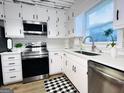 Bright kitchen featuring white cabinets, stainless steel appliances, subway tile backsplash, and modern countertops at 120 Williamsburg Way, Fayetteville, GA 30214
