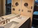 Double sink bathroom vanity with updated fixtures, framed mirror and ample counter space at 2585 Old Jackson Rd, Locust Grove, GA 30248