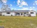 Inviting one-story brick home showcasing a sprawling front yard and covered porch with rocking chairs at 4739 Lower Jersey Rd, Oxford, GA 30054