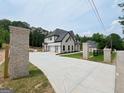 Long concrete driveway leading up to a bright, new, modern home, framed by brick pillars at 1465 Leach Dr, Lawrenceville, GA 30045