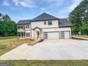 New construction home showcasing a modern garage with glass panel doors and second-story balcony at 1465 Leach Dr, Lawrenceville, GA 30045