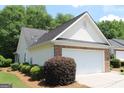 A well-maintained home with a two-car garage and landscaped shrubbery at 300 Cloverwood Dr, Fayetteville, GA 30215