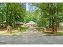 Classic brick home with well-kept lawn, surrounded by lush trees, with a long driveway leading up to the house at 145 Oxford Ln, Fayetteville, GA 30215