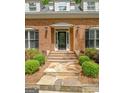 Inviting front entrance featuring a decorative glass door, stone steps, and manicured landscaping at 145 Oxford Ln, Fayetteville, GA 30215