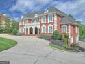 Elegant brick home with stately curb appeal, featuring a circular driveway and meticulously maintained landscaping at 205 Somerset Ct, Mcdonough, GA 30253