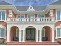 Grand front entrance with stately columns, a balcony, and double doors, creating a luxurious first impression at 205 Somerset Ct, Mcdonough, GA 30253