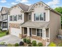 Charming home with stone accents, neutral siding, shutters, landscaped front yard, and two car garage at 3805 Alden Pl, Cumming, GA 30028