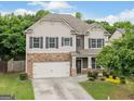 Charming home with stone accents, neutral siding, shutters, landscaped front yard, and two car garage at 3805 Alden Pl, Cumming, GA 30028