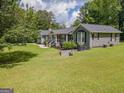 Serene home exterior featuring a manicured lawn, mature trees, and cozy front porch at 105 Greenfield Cir, Fayetteville, GA 30215