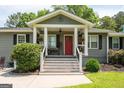 Inviting covered front porch with decorative plants and a bright red door at 105 Greenfield Cir, Fayetteville, GA 30215