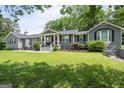 Charming single-story home with gray siding, black shutters, a well-manicured lawn, and inviting front porch at 105 Greenfield Cir, Fayetteville, GA 30215