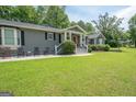 Charming single-story home with gray siding, black shutters, a well-manicured lawn, and inviting front porch at 105 Greenfield Cir, Fayetteville, GA 30215