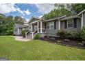 Beautifully landscaped front yard with a cozy porch and rocking chairs at 105 Greenfield Cir, Fayetteville, GA 30215