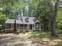 Beautiful home exterior nestled among mature trees, featuring a cozy front porch and inviting curb appeal at 686 Favorwood Sw Dr, Marietta, GA 30060