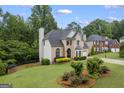 Well-maintained home showcasing a beautiful lawn, mature trees, and architectural details at 3924 Lorien Nw Way, Kennesaw, GA 30152