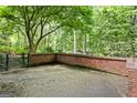 Outdoor brick patio area featuring a brick privacy wall, overlooking a lush wooded area at 3571 Lake Se Dr, Smyrna, GA 30082