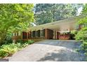 Brick home with a covered carport and a quaint entrance, surrounded by mature trees and landscaping at 3571 Lake Se Dr, Smyrna, GA 30082