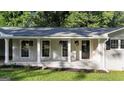 Charming covered porch with hanging floral baskets and stylish front door at 4353 White Oak Dr, Sugar Hill, GA 30518